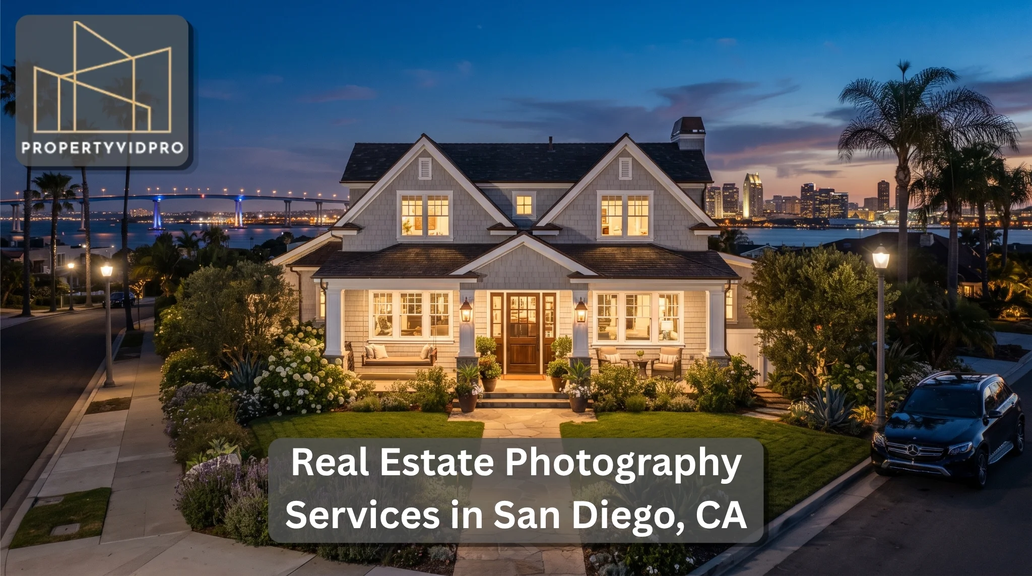 Home 36 Luxury real estate photography: Elevated curb appeal of a custom Cape Cod home in Coronado, CA, at twilight, featuring bay views, city skyline lights, and professional landscaping.